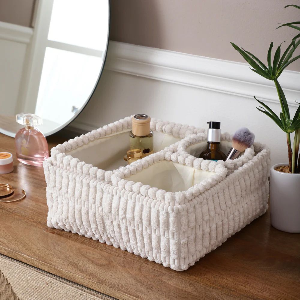 Organizador de maquillaje con textura suave color crema. Cesta de almacenamiento con compartimentos para tocador o baño.